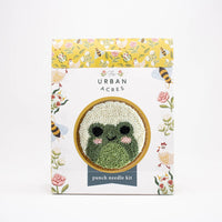 Punch needle kit packaging with a green knitted frog design on a white background.