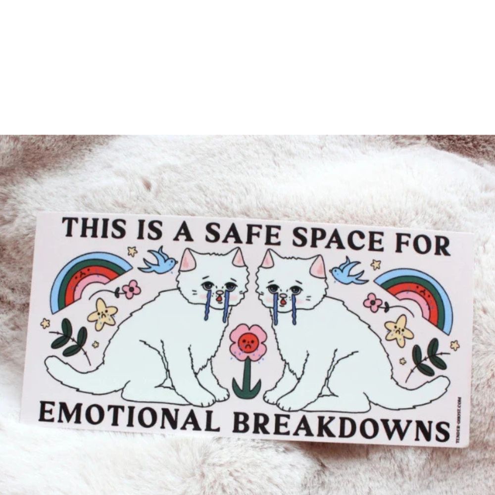 Sticker with two cats and text 'This is a safe space for emotional breakdowns' on a fluffy white surface.