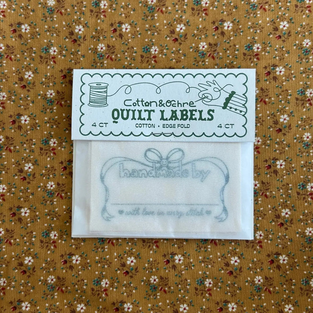 Quilt labels in a clear package on a floral fabric background