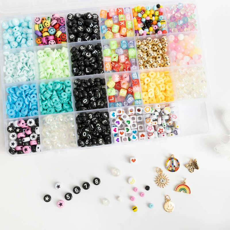 divided container with different colored beads and charms. Charms and beads are shown against a white background.