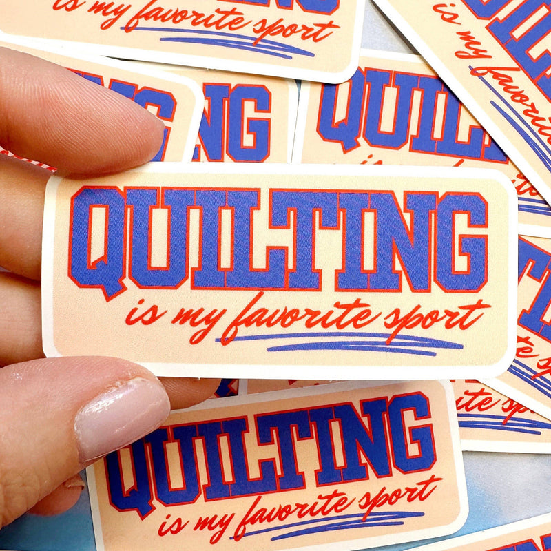 Sticker with 'Quilting is my favorite sport' text held by a hand, surrounded by more stickers.