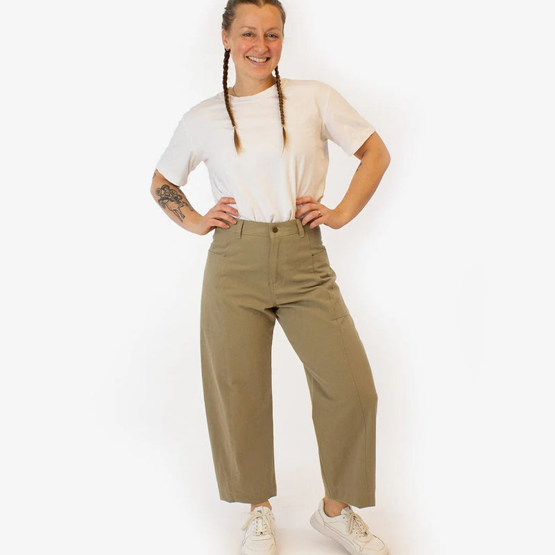 Person wearing a beige top and khaki pants on a white background