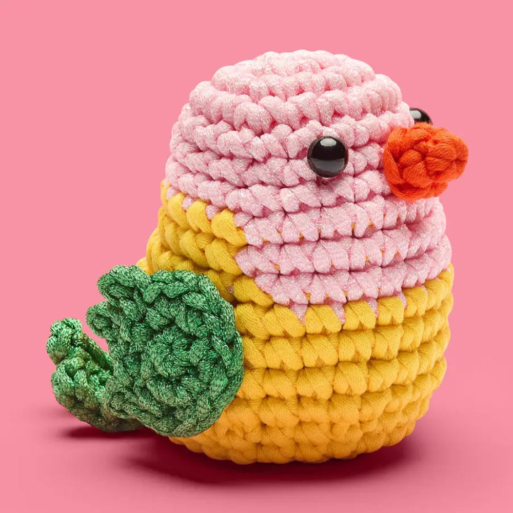 Crocheted bird with pink top and yellow body on a pink background