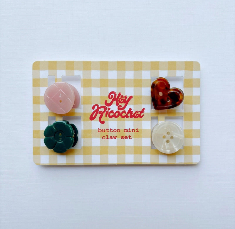 A set of five mini button clips, displayed on a yellow and white gingham card. The claws include a pink flower, a dark green flower, a pink oval, a translucent dark red heart, and a translucent cream oval, all set against a clean white background.
