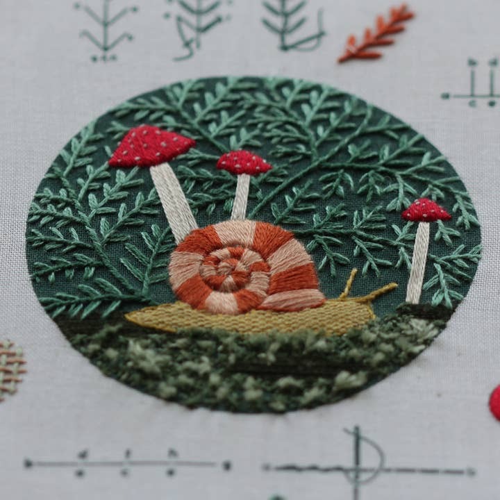 Embroidery stitch sampler with snail and mushrooms