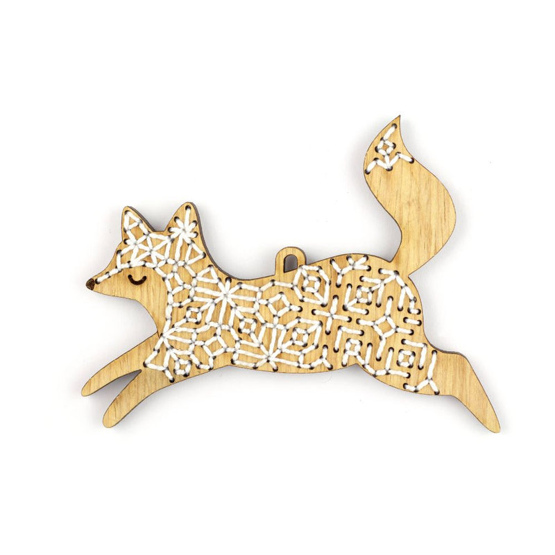 Wooden fox ornament with geometric pattern on a white background
