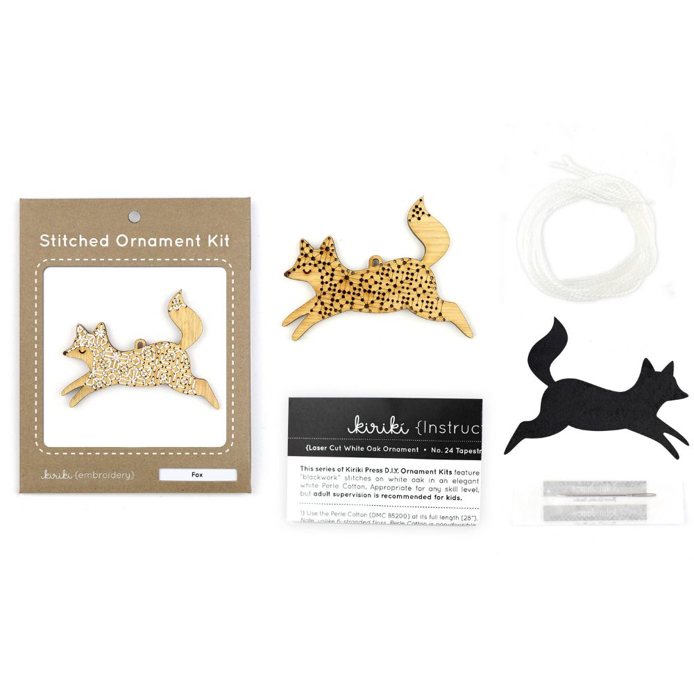 Stitched ornament kit with gold and black fox designs on a white background