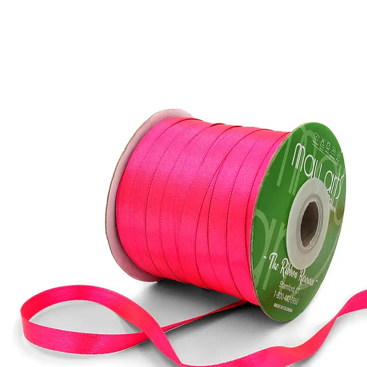 Bright pink ribbon spool with visible brand name on a white background