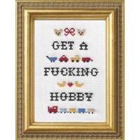Framed cross-stitched art with text and small illustrations on a white background