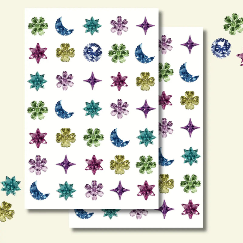 Sheet of colorful gemstone stickers with stars, moons, and flowers on a white background.