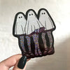 Holographic ghost high heel shoes held by a hand with dark nail polish on a light background