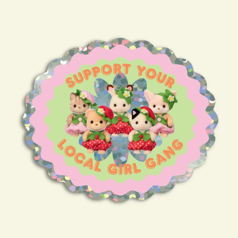 Circular sticker with cartoon characters and text 'Support Your Local Girl Gang' on a light beige background.
