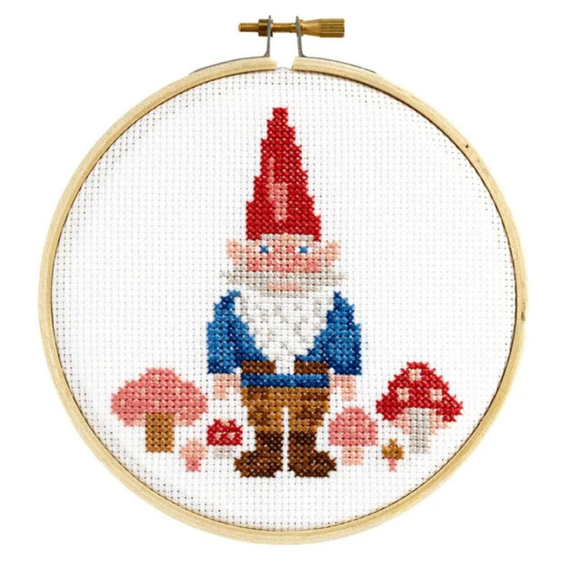 Cross-stitched gnome with red hat and mushrooms in a wooden hoop on a white background