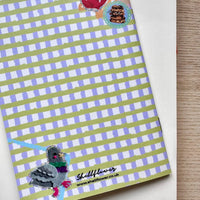Notebook with green and purple gingham cover featuring a bird illustration and 'Shellflower' branding.
