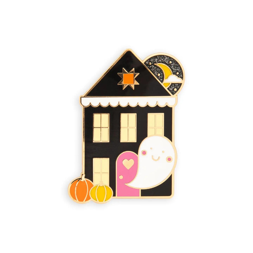 A Halloween-themed enamel pin shaped like a house with a smiling ghost, quilt star shaped window, pumpkins, and a crescent moon on a plain white background.