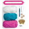Content of the kit including yarn, loom, hook, buttons, sewing needle, needle threader, gift tags and patch