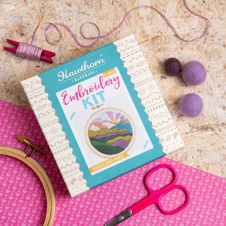 Embroidery kit with hoop, scissors, and thread on a wooden surface