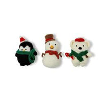 Three small crocheted toys shaped like a penguin, snowman, and polar bear on a white background