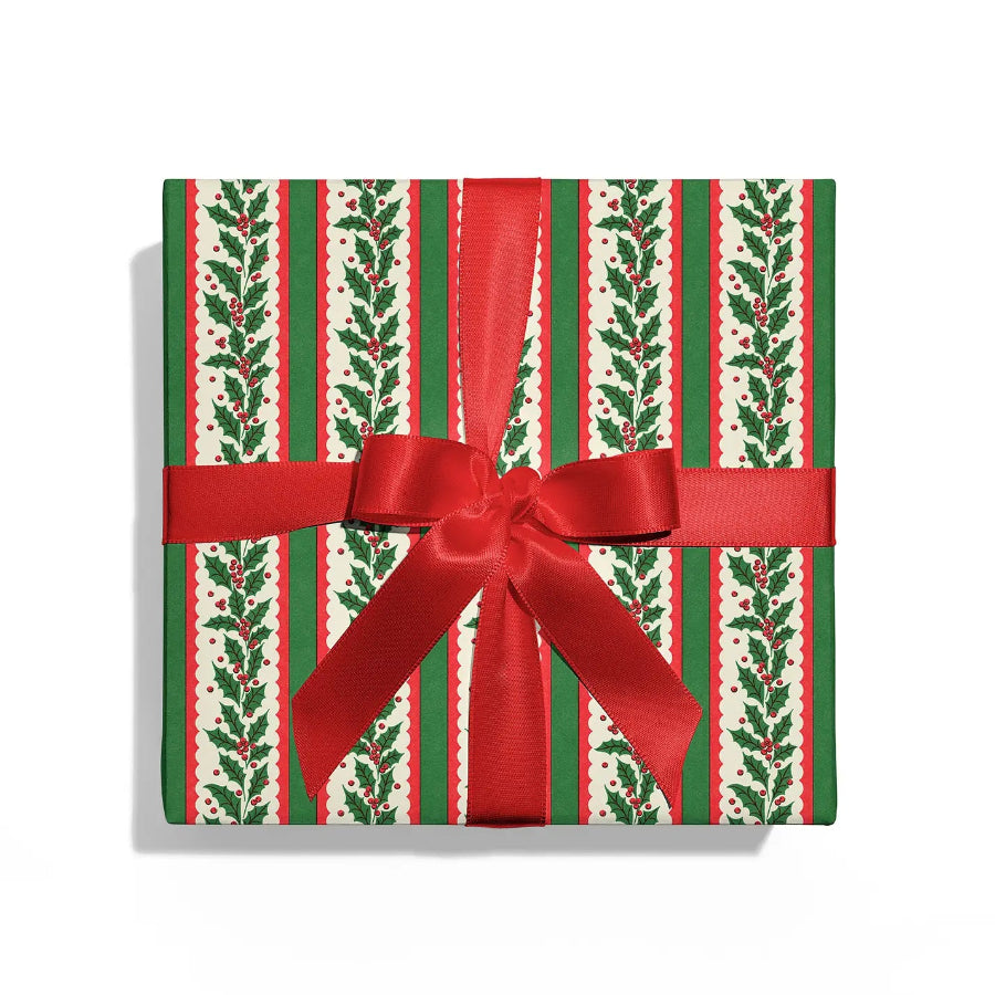 Gift box with holly leaf pattern and red ribbon on a white background