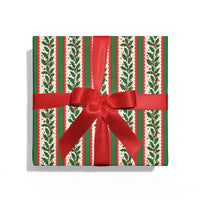 Gift box with holly leaf pattern and red ribbon on a white background