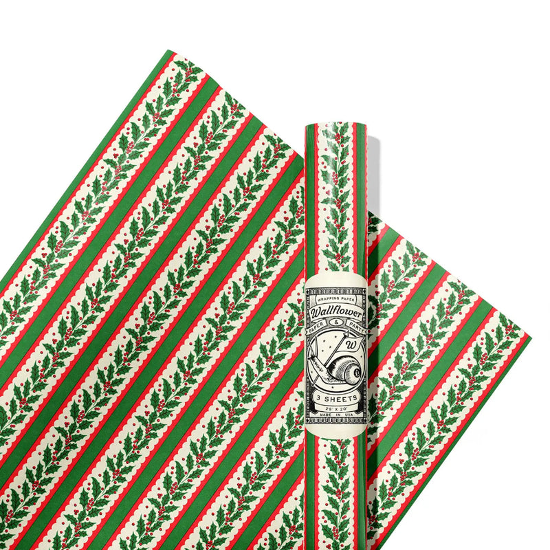 Red and green striped wrapping paper with a ribbon on holly on a white background