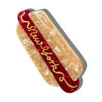 Hair clip in the shape of a hot dog with text reading "New York"