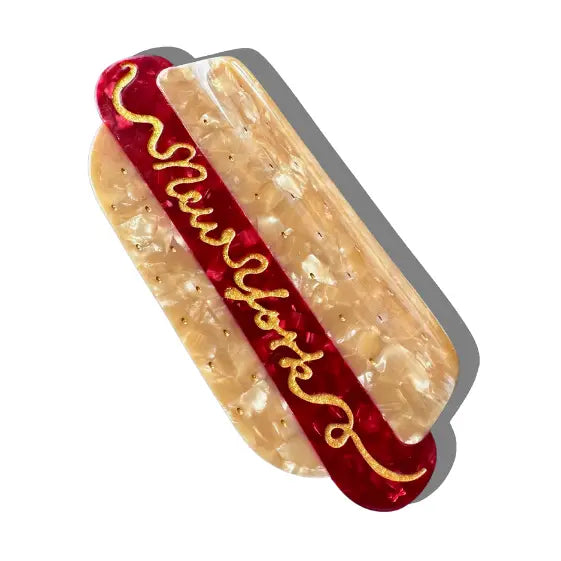 Hair clip in the shape of a hot dog with text reading "New York"