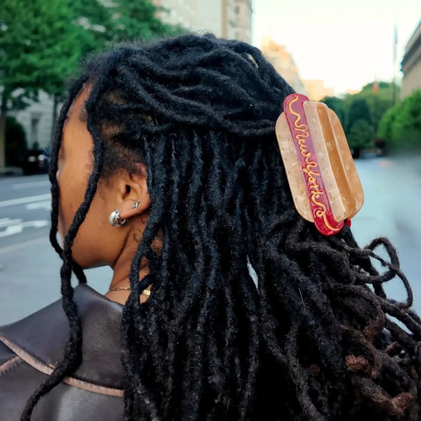 Person with dreadlocks wearing a hot dog shaped hair clip.