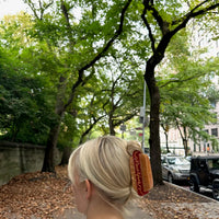Person with straight hair wearing a hot dog shaped hair clip.