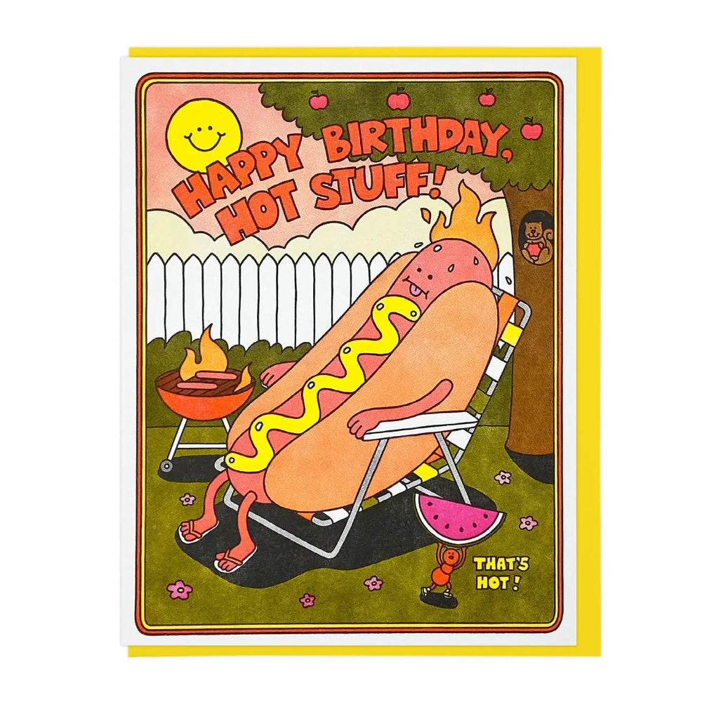 Birthday card with a cartoon hot dog in a lawn chair, next to a grill. There is text that reads "Happy Birthday, Hot Stuff!" and "That's Hot".