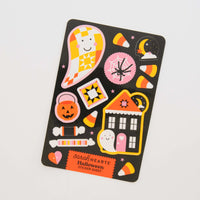 A Halloween-themed sticker sheet by Sarah Hearts, featuring cute illustrations of a ghost, jack-o'-lantern, candy corn, spider, haunted house, and quilted star on a black background, photographed on a white surface.