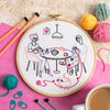 Embroidery kit with two women doing knit and crochet at.a table
