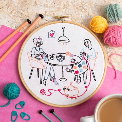 Embroidery kit with two women doing knit and crochet at.a table