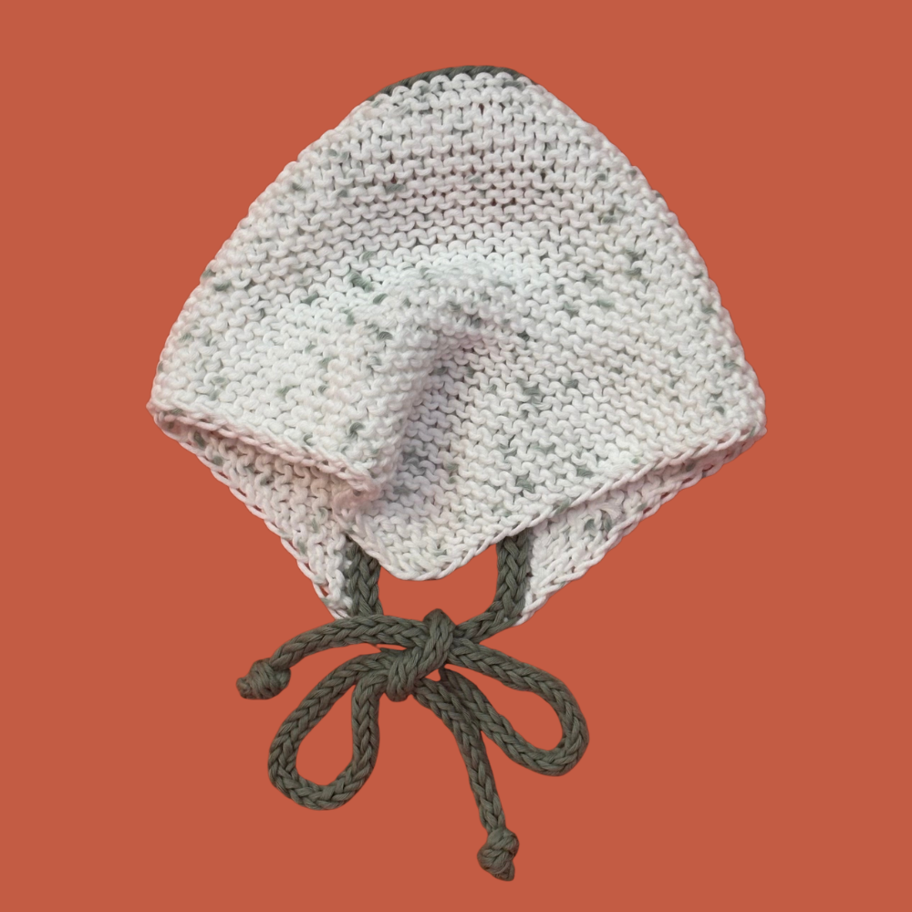 Knitted bandana with green strings on an orange background