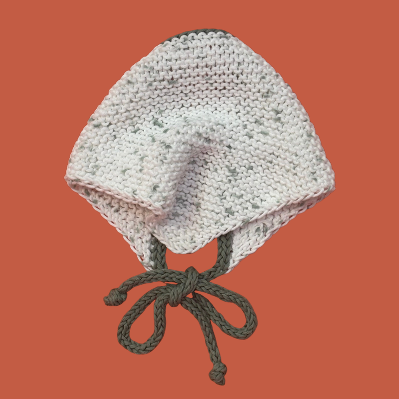 Knitted bandana with green strings on an orange background