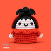 Crocheted toy resembling a character from 'Beetlejuice' on an orange background