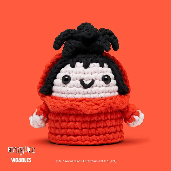 Crocheted toy resembling a character from 'Beetlejuice' on an orange background