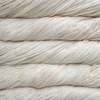 Close-up of beige yarn skeins stacked on a light background