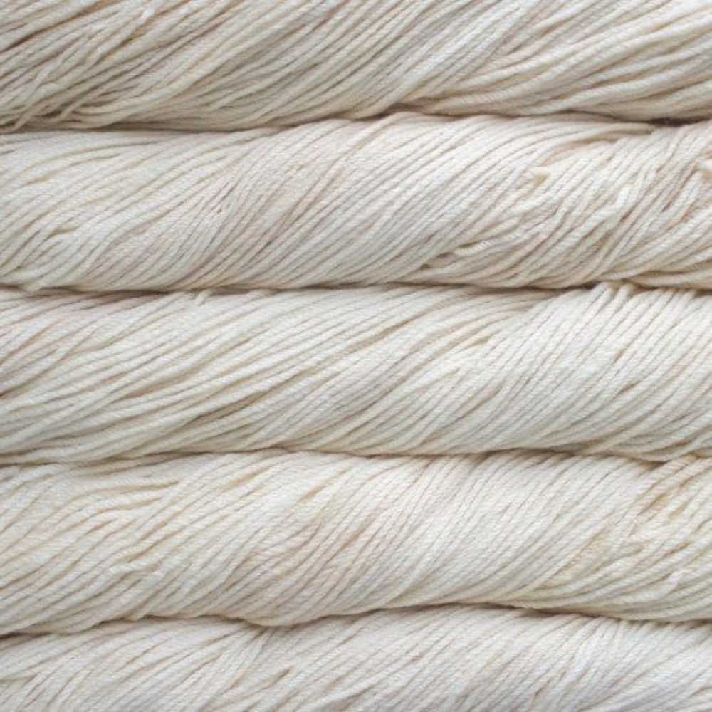 Close-up of beige yarn skeins stacked on a light background