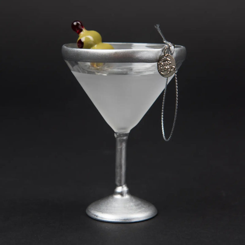 Cocktail ornament in a martini glass with olives on a black background