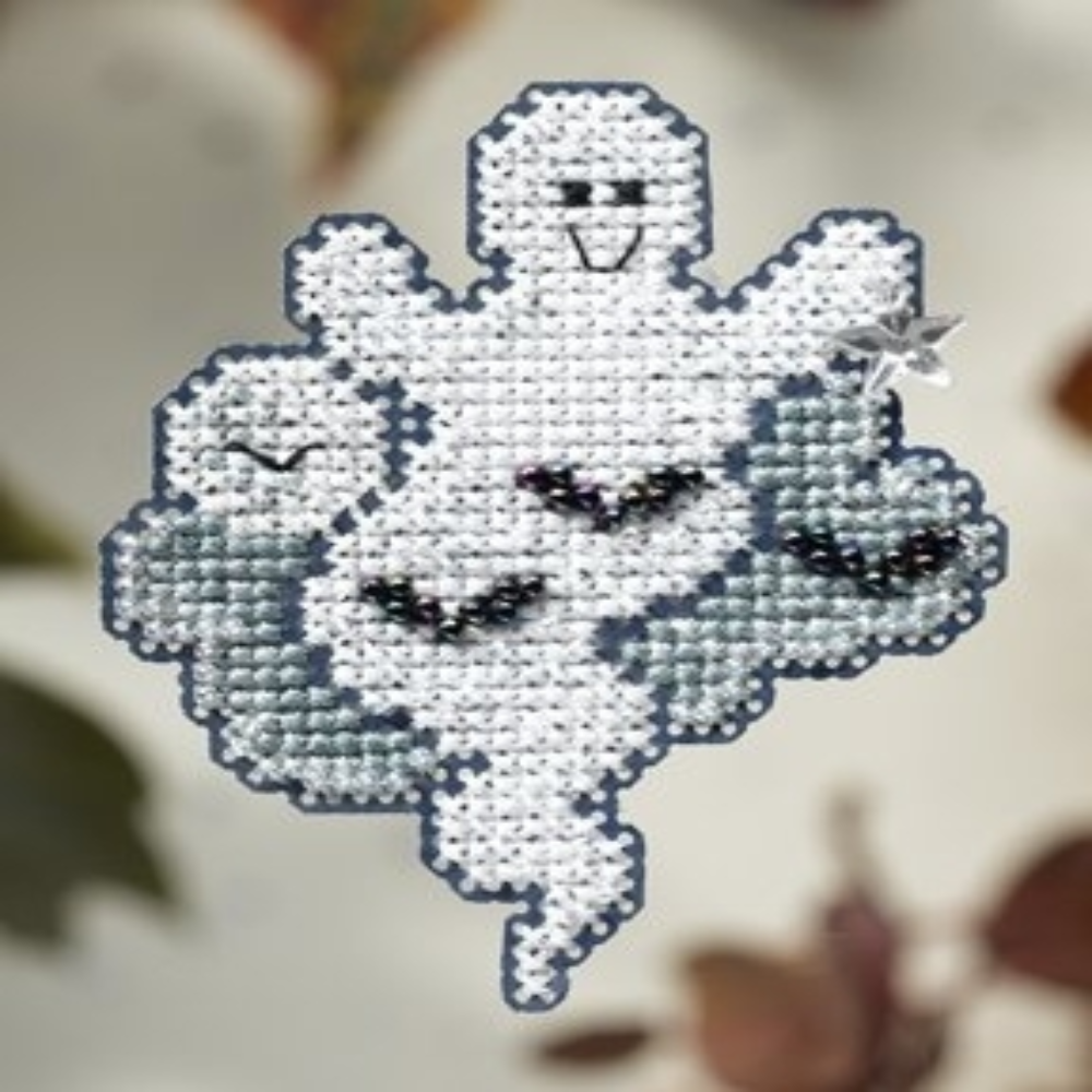 Cross-stitched ghost design on fabric with a blurred background