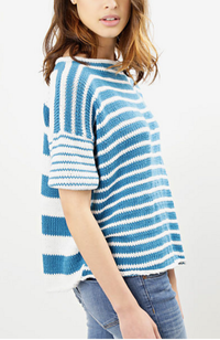 Model with brown hair wearing jeans and a blue and white striped top on a white background.