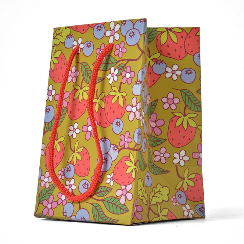 Gift bag with berry and floral pattern on a white background.
