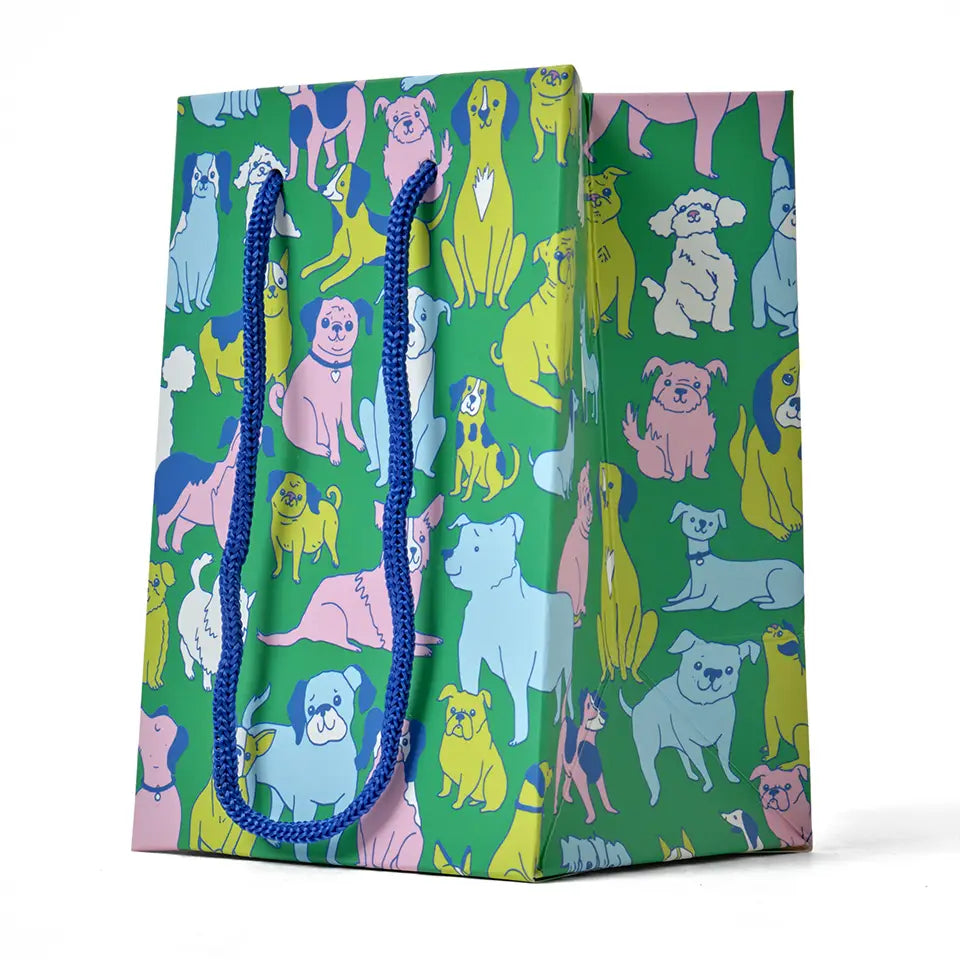 Gift bag patterned with many multicolor dogs on a white background.