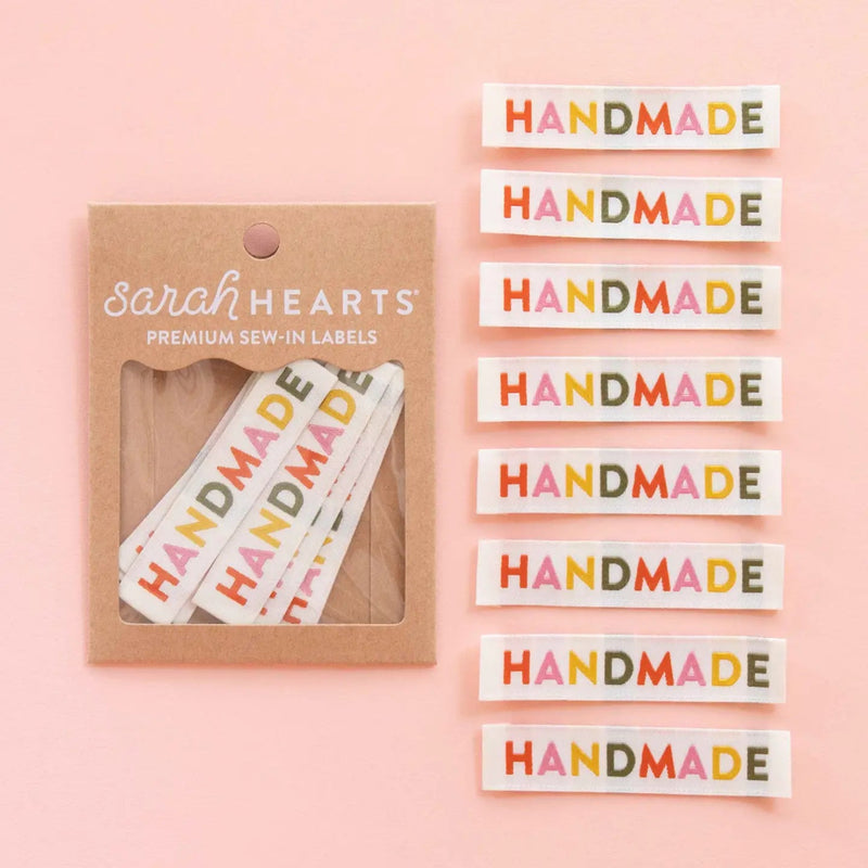 Packaging of 'HANDMADE' labels by Sarah Hearts on a pink background