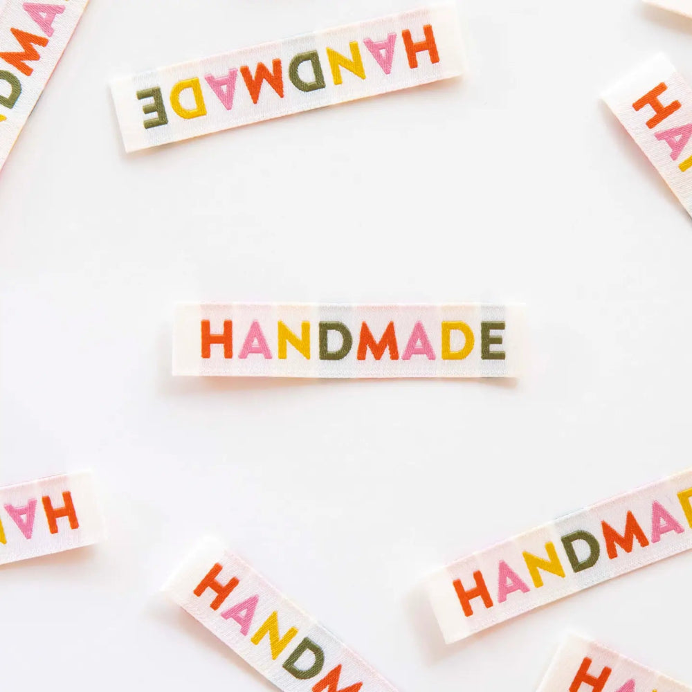 Colorful 'HANDMADE' labels scattered on a white background