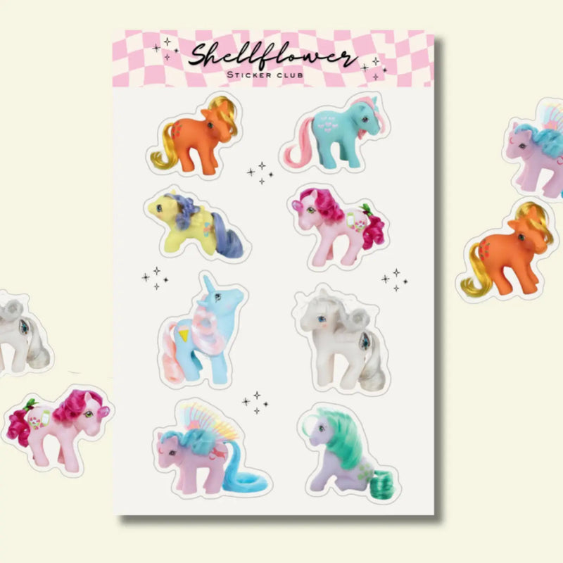 Sheet of colorful pony stickers with 'Shellflower Sticker Club' branding on a light pink background.