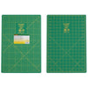 Two green cutting mats with grid lines on a white background