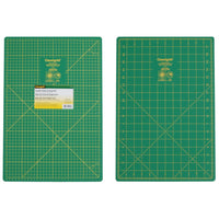 Two green cutting mats with grid lines on a white background