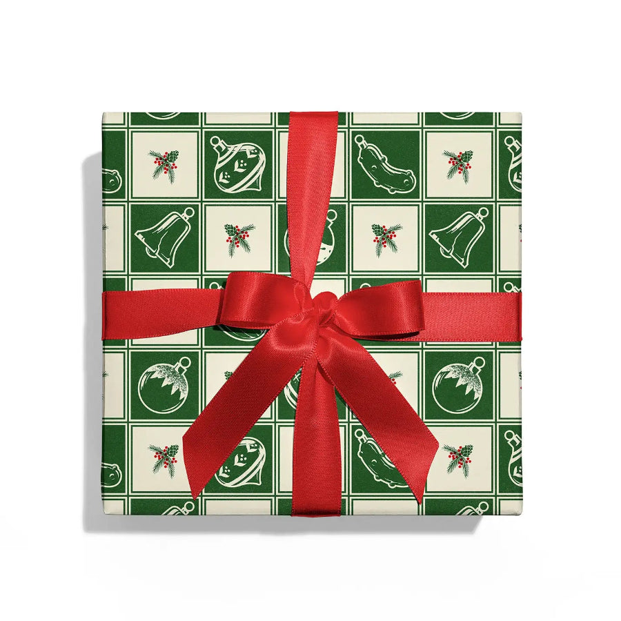 Gift box with green and white pattern and red ribbon on a white background